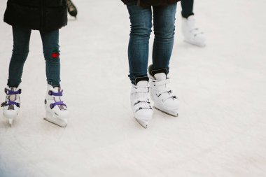 İceskating üzerinde paten patenciler Avrupa şehir merkezinde kış tatil halka. Beyaz oynayan çocuklar buz pateni halka, sağlıklı faaliyet buz. Alt bacaklar beyaz paten