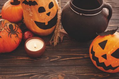 Mutlu Cadılar Bayramı kavramı. Kabaklar cadı kazanı, yarasalar, örümcek, mum ışığı ve ahşap arka plan üzerinde sonbahar yaprakları