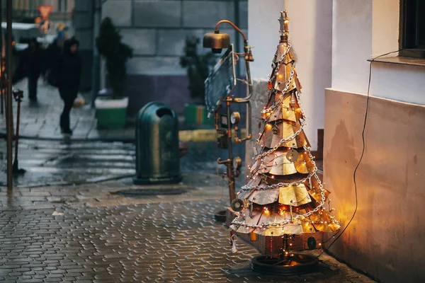 蒸汽朋克圣诞树 创意钢树与金属装饰品和树枝 时尚的圣诞装饰品和花环灯在欧洲城市街道 节日装饰 冬季假期 — 图库照片