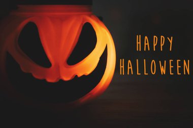 Mutlu Halloween metin işareti. Cadılar Bayramı Balkabağı Jack o fener parlayan yüzünde korkunç izole koyu siyah arka plan ile. Karanlıkta parlayan ürkütücü yüzü. Sezonun tebrik kartı