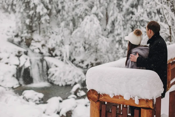 Elegante Pareja Abrazándose Mirando Los Bosques Nevados Desde Porche Madera —  Fotos de Stock