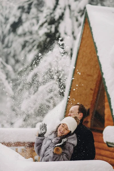 Stilvolles Paar Spielt Mit Schnee Holzhütte Vor Dem Hintergrund Der — Stockfoto