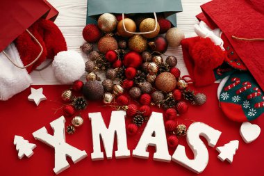 Mutlu Noeller. Xmas word çanta, santa şapka ve alışveriş torbaları düz çorap kırmızı ve altın baubles ile yatıyordu. Sezonun tebrik kartı. Yaratıcı tatil görüntü. Noel metin