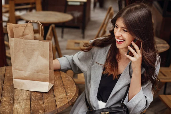 Красивая Молодая Женщина Разговаривает Телефону Улыбается Чашкой Кофе Бумажным Пакетом — стоковое фото