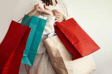Noel alışveriş ve mevsimlik Satılık. Mutlu kız kırmızı ve yeşil kağıt poşetler tutan kazaklı. Alışveriş Merkezi. Noel satış. Metin için yer. 