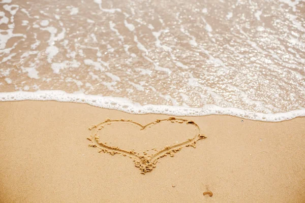 海の近くの波と砂浜に書かれた心 愛の概念 幸せなバレンタインデー 新婚夫婦の新婚旅行 バレンタインの日 テキストのためのスペース 楽しい休暇をお過ごしください — ストック写真