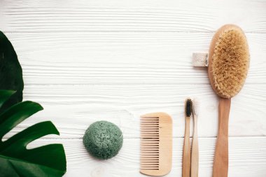 Doğal katı şampuan bar, bambu diş fırçaları, ahşap fırça, deodorant krem ve beyaz tahta üzerinde konjaku sünger