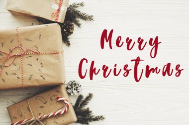 Neşeli Noel metin üstünde Noel şık kırmızı kurdele, şeker kamışı, Çamın dalları ve koniler ile sunar. Dilekler kartı. Mutlu bayramlar ve mutlu yeni yıl