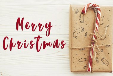 Neşeli Noel metin üstünde Noel şık kırmızı kurdele, şeker kamışı, Çamın dalları ve koniler ile sunar. Dilekler kartı. Mutlu bayramlar ve mutlu yeni yıl