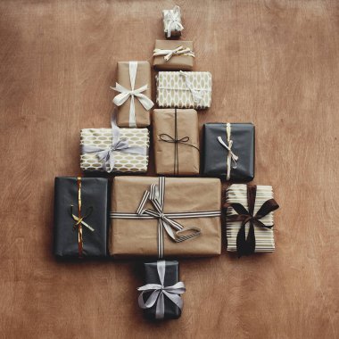 Rustik ahşap arka plan ağaç şeklinde Noel şık hediye kutuları. Modern siyah ve altın sunar ağaç şeklinde, düz yatıyordu. Mevsim Selam, Festival yaratıcı fotoğraf. Mutlu Noeller
