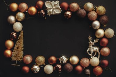 Noel altın hediye kutusu, ağaç, Ren geyiği ve parlak baubles şık siyah arka plan üzerine çerçeve. Noel düz metin için yer yatırın. Mevsim Selam, kart mockup