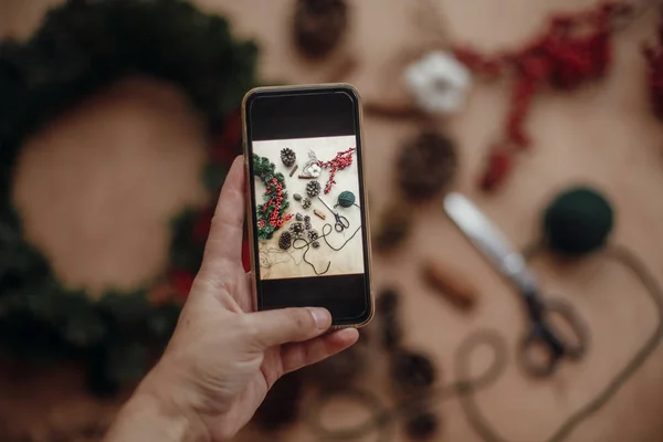 Mano Sosteniendo Teléfono Tomar Una Foto Rústica Corona Navidad Plana — Foto de Stock