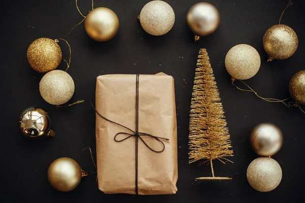 ゴールドのクリスマス ツリーとギフト ボックス スタイリッシュな黒い背景にキラキラつまらない 現代のクリスマス フラット レイアウト イメージ 季節のグリーティング カード — ストック写真
