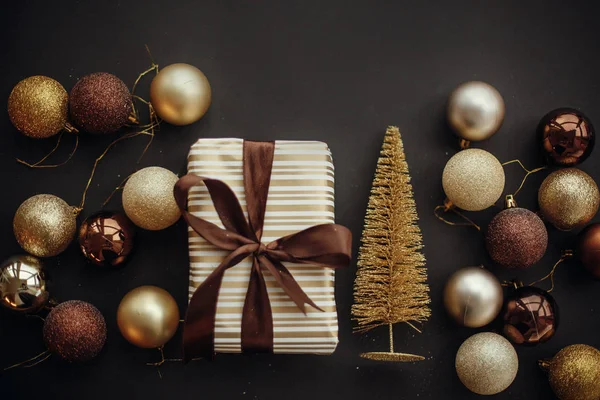 キラキラ ツリーとモダンな黒い背景につまらないクリスマス スタイリッシュなギフト ボックス フラットが横たわっていた モダンなブラウンとゴールドの装飾と現在 季節のご挨拶 メリークリスマス — ストック写真