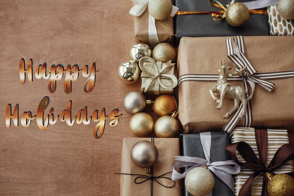 快乐假期文字 手写的金色标志在圣诞时尚礼品盒与闪闪发光的树和装饰品质朴的木制背景 节日贺卡 — 图库照片