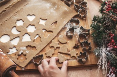 Noel zencefilli kurabiye ağacı ahşap oklava, tanımlama bilgileri, metal kesiciler, Noel süsleri rustik masa üzerinde arka plan üzerinde tutan el. Çocuk ile kurabiye yapma süreci