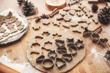 Zencefilli kurabiye hamuru ile Noel kurabiyeleri ahşap oklava, tarçın, anason, koniler, Noel süsleri rustik tablo için metal kesiciler. Atmosferik şık görüntü