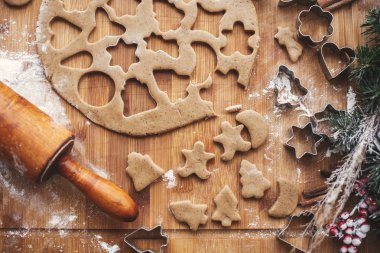 Noel kurabiyeleri düz yatıyordu. Ahşap oklava, tarçın, anason, koniler, Noel süsleri ile rustik tabloda metal kesiciler ile hamur. Kurabiye, atmosferik resim yapma