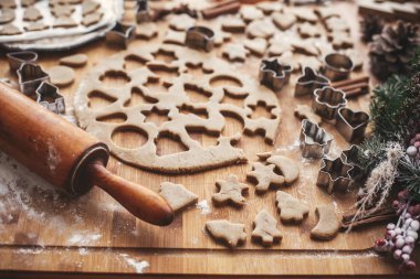 Noel zencefilli kurabiye yapma. Ahşap oklava, tarçın, anason, koniler, Noel süsleri ile rustik tabloda metal kesiciler ile hamur. Atmosferik şık görüntü