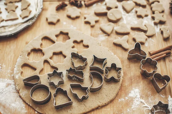 Noel zencefilli kurabiye yapma. Tarçın, anason, koniler, Noel süsleri ile rustik tabloda metal kesiciler ile hamur. Atmosferik şık görüntü, kış tatili