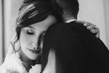 Muhteşem gelin ve yavaşça sarılma ve güneşli sokakta kucaklayan şık damat. Güzel mutlu evlilik çift portreleri. Romantik duygusal an. Gerçek aşk