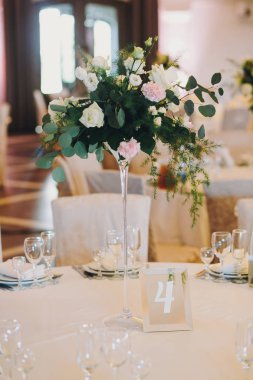 Gül buketleri, tabaklar, Gözlük, çatal bıçak takımı düğün resepsiyon ile şık bir şekilde dekore edilmiş Tablolar. Lüks yemek servisi. Noel ve yeni yıl Bayramı. Kutlamalar ve parti konsept.