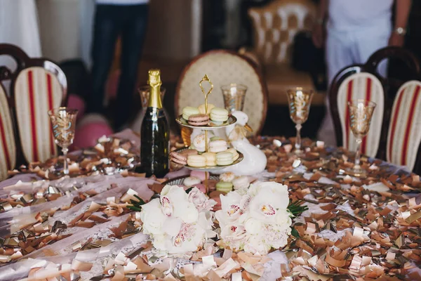 빈티지 스탠드에 Macarons와 색종이 테이블에 샴페인 럭셔리 음식입니다 — 스톡 사진