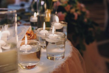 Mum ışıklı gözlük ile su, şık düğün dekor töreni akşam için veya restoranda resepsiyonda. Manevi kutsal romantik anlar