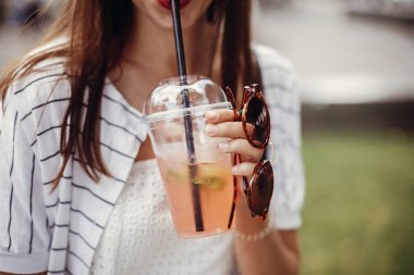 Tek Kişilik Kullanım plastik yasak. Plastik kap ve saman tutan mutlu hippi kız retro elbiseli. Soğuk içecek tutarak ve şehir sokak rahatlatıcı güzel şık genç kadın.