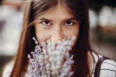 Lavanta Buket kokusu zevk mutlu hippi kız. Sakin atmosferik an. Lavanta çiçekleri şaşırtıcı ve güneşli havada kokulu tutan güzel şık genç kadın.