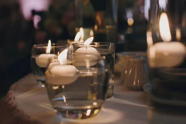 夜の式やレストランでのレセプションでスタイリッシュな結婚式の装飾 水とガラスのライトとキャンドル 精神的な神聖なロマンチックな瞬間 — ストック写真