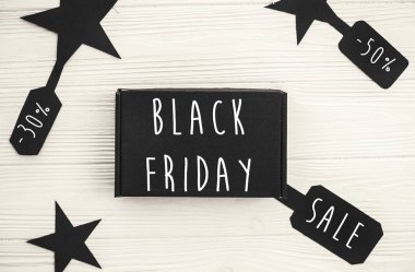 Fiyat etiketi işareti üzerinde siyah Cuma büyük bir satış metin, minimalist düz yatıyordu. Özel indirim Noel teklif. Beyaz rustik arka plan üzerinde siyah hediye kutuları, şık reklam mesajı. Noel alışveriş