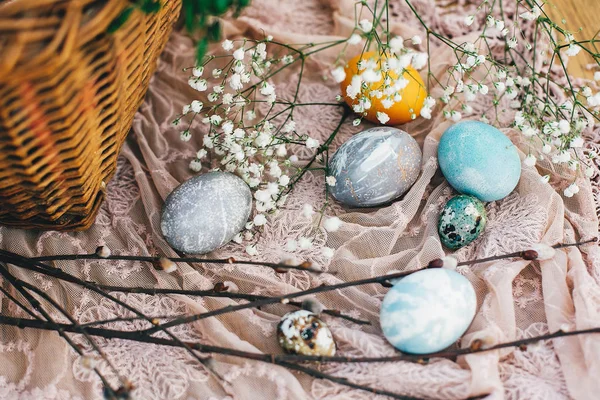 时尚的复活节彩蛋 在木制背景的乡村篮子里 在布上有鲜花和树枝 复活节狩猎的概念 用天然染料涂漆的现代复活节彩蛋 复活节快乐 — 图库照片