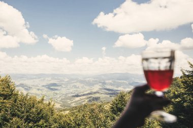 Cam limonata içki, güzel manzara orman ve dağlar odaklanmak ile tutan el. Metin için yer. Seyahat ve tatil