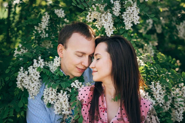 Hermosa Pareja Joven Abrazándose Suavemente Hojas Verdes Flores Blancas Jardín —  Fotos de Stock