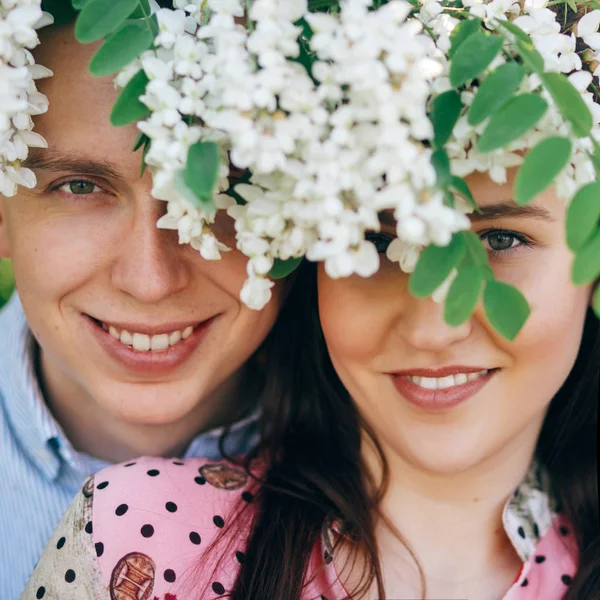 Hermosa Pareja Joven Posando Sonriendo Bajo Flores Blancas Jardín Primavera — Foto de Stock