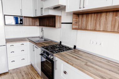 Şık mutfak iç tasarım. Lüks modern mutfak mobilya gri renk ve çelik fırın, buzdolabı, lavabo, ahşap masa üstü. İskandinav tarzı gri dolaplarında. Ev yenileme