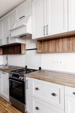 Lüks modern mutfak mobilya gri renk ve çelik fırın, buzdolabı, lavabo, ahşap masa üstü. İskandinav tarzı gri dolaplarında. Ev yenileme. Şık mutfak dekorasyon.
