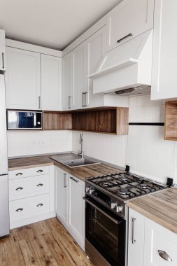 Şık mutfak iç tasarım. Lüks modern mutfak mobilya gri renk ve çelik fırın, buzdolabı, lavabo, ahşap masa üstü. İskandinav tarzı gri dolaplarında. Ev yenileme