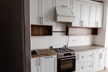 Lüks modern mutfak mobilya gri renk ve çelik fırın, buzdolabı, lavabo, ahşap masa üstü. İskandinav tarzı gri dolaplarında. Ev yenileme. Şık mutfak dekorasyon.