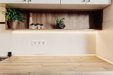 Lüks modern mutfak mobilya gri renk ve ahşap masa üstü. Metin için yer. Baharat ile raf. İskandinav tarzı gri dolaplarında. Ev yenileme. Şık mutfak dekorasyon.