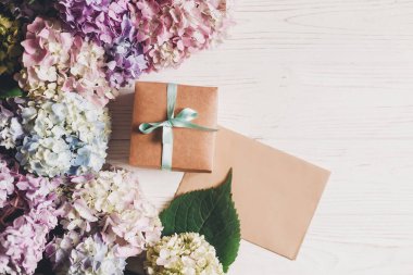 Güzel ortanca çiçek, Hediyelik kutu ve kağıt tebrik kartı üzerinde rustik ahşap beyaz, düz metin için yer yatırın. Mutlu anneler günü tebrik kartı mockup. Dünya Kadınlar günü. Sevgililer