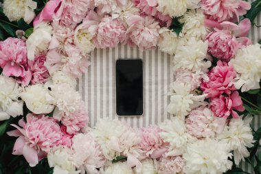 Telefon ile düz peonies çerçevede boş perde rustik masa örtüsü üzerinde yatıyordu. Metin için yer. Tebrik kartı mockup. Mutlu anneler günü. Uluslararası Kadınlar günü. Sevgililer günü.