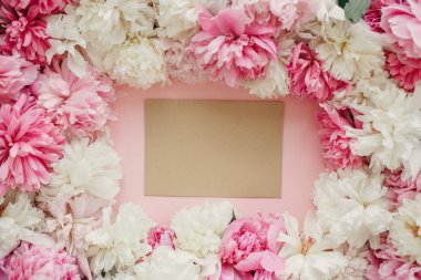 Pembe ve beyaz peonies pastel pembe kağıt üzerinde boş kart ile. Uzay kopyalayın. Şık yaratıcı düz yatıyordu. Mutlu anneler günü, çiçek tebrik kartı mockup. Uluslararası Kadınlar günü. Sevgililer günü