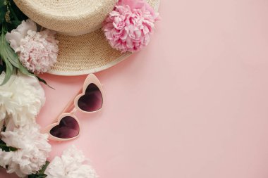 Şık kız gibi pembe retro güneş gözlüğü, beyaz ve pembe peonies, hasır şapka kopya alanı ile pastel pembe kağıt üzerinde. Bahar kavramı Merhaba. Yaz tatili düz yatıyordu. Dünya Kadınlar günü