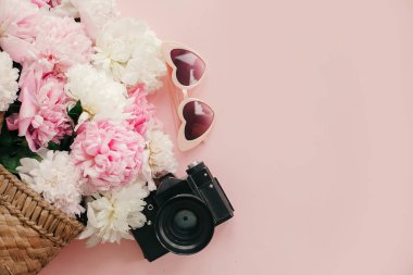 Yaz tatil kavramı, düz yatıyordu. Hasır çanta, fotoğraf makinesi, şık pembe peonies kopya alan gazeteyle retro güneş gözlüğü üzerinde pastel pembe. Dünya Kadınlar günü. Merhaba bahar