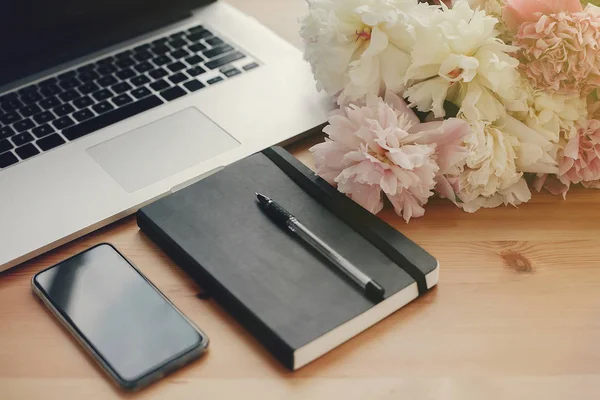 Stilvoller Laptop Telefon Mit Leerem Bildschirm Schwarzes Notizbuch Pfingstrosen Auf — Stockfoto