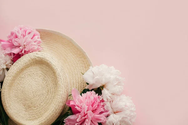 Bahar görüntü kopya alanı ile Merhaba. Yaz tatil kavramı. Beyaz ve pembe peonies pastel pembe kağıt, düz ile hasır şapka yatıyordu. Dünya Kadınlar günü. Mutlu anneler günü