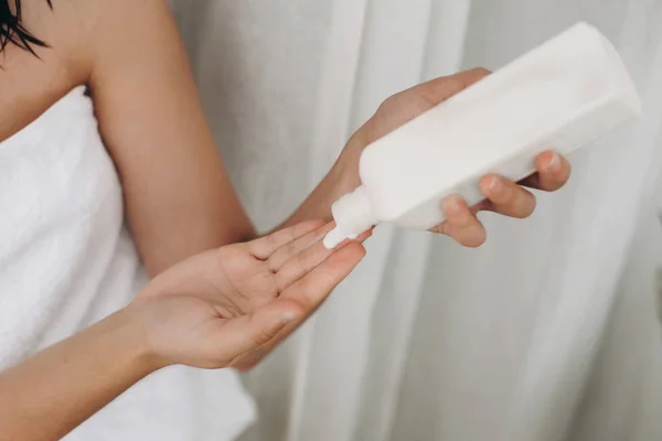 Jovem Mulher Toalha Branca Segurando Garrafa Com Loção Creme Banheiro — Fotografia de Stock