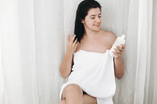 Joven Mujer Feliz Toalla Blanca Sosteniendo Crema Hidratante Botella Baño —  Fotos de Stock